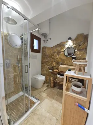 a bathroom with a shower and a toilet at Villa Cerasella - Rustic Sicilian Retreat with Private Pool & Sunset View in Trappeto