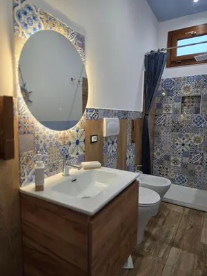 a bathroom with a sink and a toilet and a mirror at Villa Cerasella - Rustic Sicilian Retreat with Private Pool & Sunset View in Trappeto
