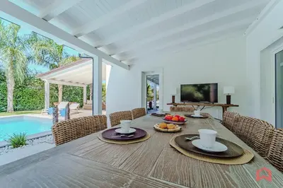 a dining room with a table and a pool at Esclusiva Villa con Piscina Privata a Mondello in Palermo