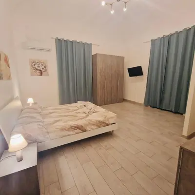 a bedroom with a bed in a room with blue curtains at Palermo House 29-Central Station in Palermo