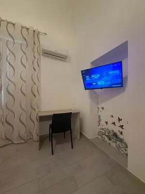 a room with a desk and a television on a wall at Palermo House 29-Central Station in Palermo