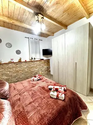 a bedroom with a large red bed with two dolls on it at Family house in Palermo