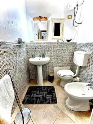 a bathroom with a toilet and a sink at Family house in Palermo