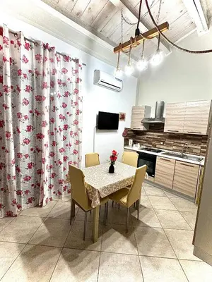 a dining room with a table and chairs in a kitchen at Family house in Palermo