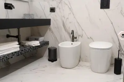 a white bathroom with a sink and a toilet at Algaria Sicilian Suites in Palermo