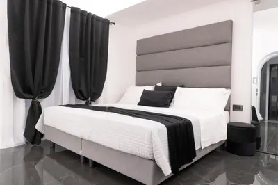 a bedroom with a bed and a table and a table and chair at Algaria Sicilian Suites in Palermo