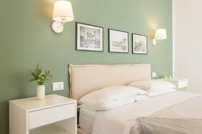 a bedroom with green walls and a bed with white pillows at Donna Lia Apartment in Palermo