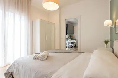 a white bedroom with a bed with two towels on it at Donna Lia Apartment in Palermo
