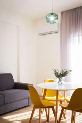 a living room with a table and yellow chairs at Don Federico Apartment in Palermo