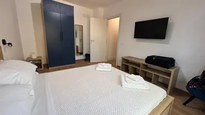 a bedroom with a white bed and a television at La Casa di Simo in Palermo