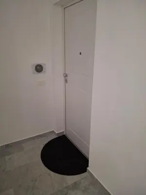 a white room with a door and a black rug at La Casa di Simo in Palermo