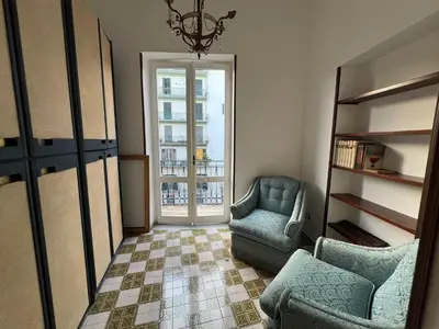 a living room with a chair and a couch and a window at Cluverio House Apartment in Palermo