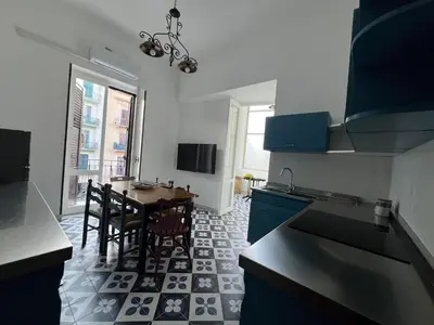 a kitchen with a table and a dining room at Cluverio House Apartment in Palermo
