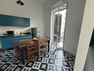 a kitchen with a wooden table and chairs in a room at Cluverio House Apartment in Palermo