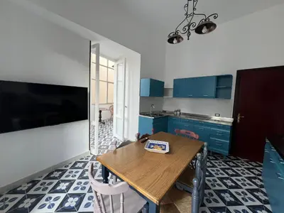 a kitchen with blue cabinets and a wooden table at Cluverio House Apartment in Palermo