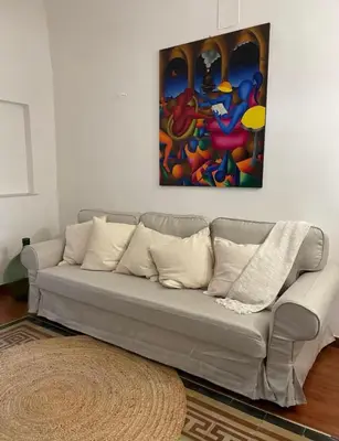 a couch in a living room with a painting on the wall at Casa Levante in Palermo
