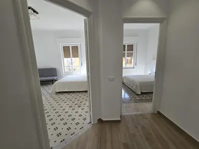 a white room with two beds and a mirror at GiuAdel casa Palermo in Palermo