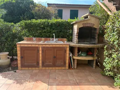 a outdoor kitchen with a pizza oven in a backyard at Casa Vacanza Pinto a 80 mt dal mare in Campofelice di Roccella