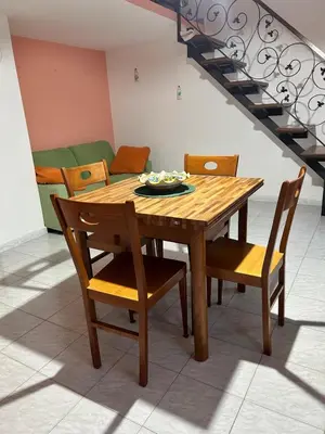 a wooden dining room table with chairs and a staircase at Casa Vacanza Pinto a 80 mt dal mare in Campofelice di Roccella