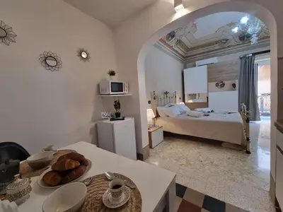 a room with a bed and a table with bread on it at Donna Elisa by Holiday World in Carini