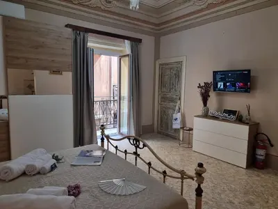 a bedroom with a bed and a window and a television at Donna Elisa by Holiday World in Carini