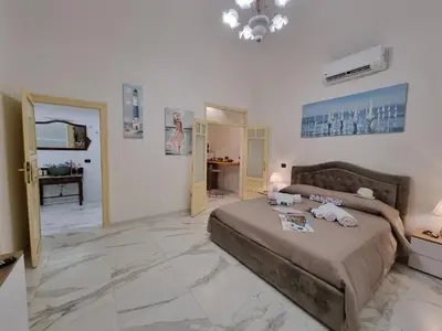 a bedroom with a bed and a living room at Donna Lidia by Holiday World in Carini
