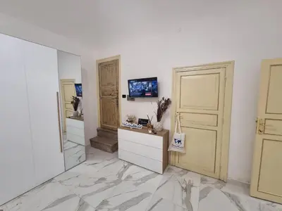 a white room with a mirror and a tv on a wall at Donna Lidia by Holiday World in Carini