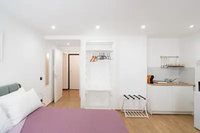 a bedroom with a purple bed and a kitchen at ControCanto Elegant Stay - 3 bedroom flat in Palermo