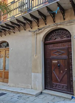 a large wooden door on the side of a building at A casa di Adele in Castellammare del Golfo