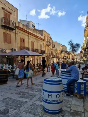 a group of people walking around a street with buildings at A casa di Adele in Castellammare del Golfo