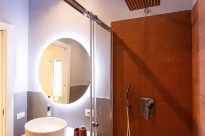 a bathroom with a shower with a sink and a mirror at Don Federico - For Couple in Palermo