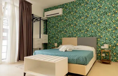a bedroom with a bed with a green floral wallpaper at Cielo D'Alcamo Palazzo Oliva in Alcamo