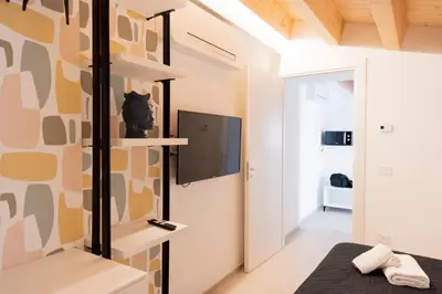 a bedroom with a bed and a tv on a wall at Cielo D'Alcamo Palazzo Oliva in Alcamo