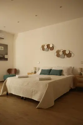 a bedroom with a large bed with two plates on the wall at Sikelìa Apartment in Carini
