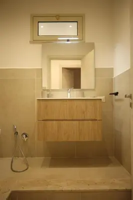 a bathroom with a shower and a sink and a mirror at Sikelìa Apartment in Carini