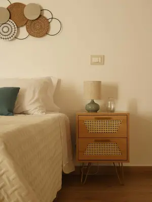 a bedroom with a bed and a nightstand with a lamp at Sikelìa Apartment in Carini