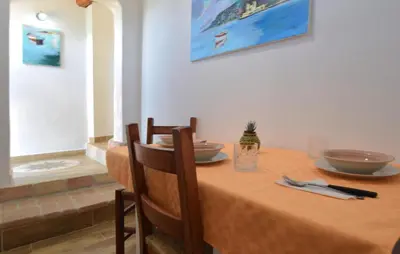 a dining room table with chairs and a orange table cloth at Amazing Home In San Cipirello With Swimming Pool in San Cipirello