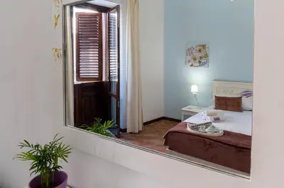 a mirror in a room with a bed and a bedroom at La Casa di Orlando Palermo in Palermo