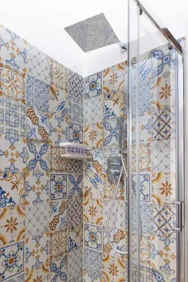 a shower in a bathroom with blue and white tiles at La Casa di Orlando Palermo in Palermo