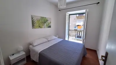 a white bedroom with a bed and a window at San Marco Rooms in Palermo