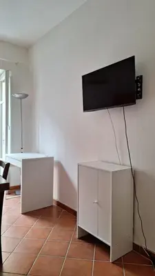 a living room with a flat screen tv on a wall at San Marco Rooms in Palermo