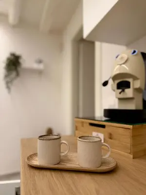 two coffee mugs sitting on a plate on a table at Seraphia Apartment in Palermo