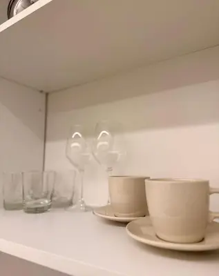 a shelf with wine glasses and cups on it at Seraphia Apartment in Palermo