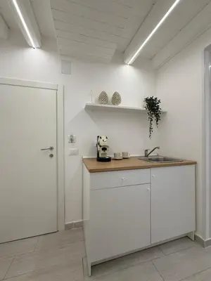 a kitchen with white walls and a counter with a sink at Seraphia Apartment in Palermo