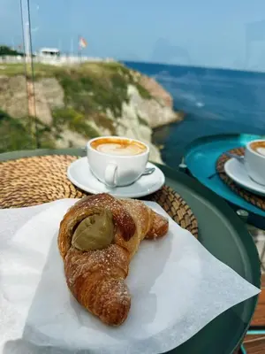 a pastry on a table with a cup of coffee at La Finestra Sul Tirreno in Terrasini