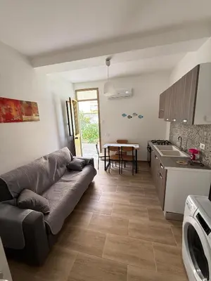 a living room with a couch and a table in a kitchen at La Finestra Sul Tirreno in Terrasini