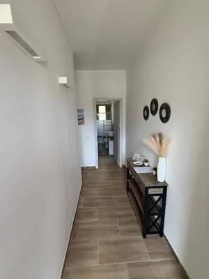 a hallway with white walls and a wooden table at La Finestra Sul Tirreno in Terrasini