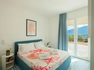 a bedroom with a bed and a large window at Villa Verde Essence in Castellammare del Golfo