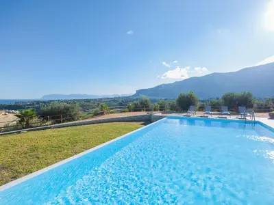 a large swimming pool with mountains in the background at Villa Verde Essence in Castellammare del Golfo