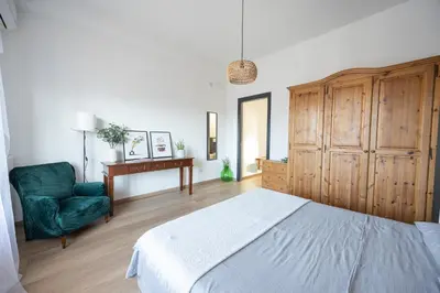 a bedroom with a bed and a chair and a desk at Taléa - Design Apartment a Palermo in Palermo